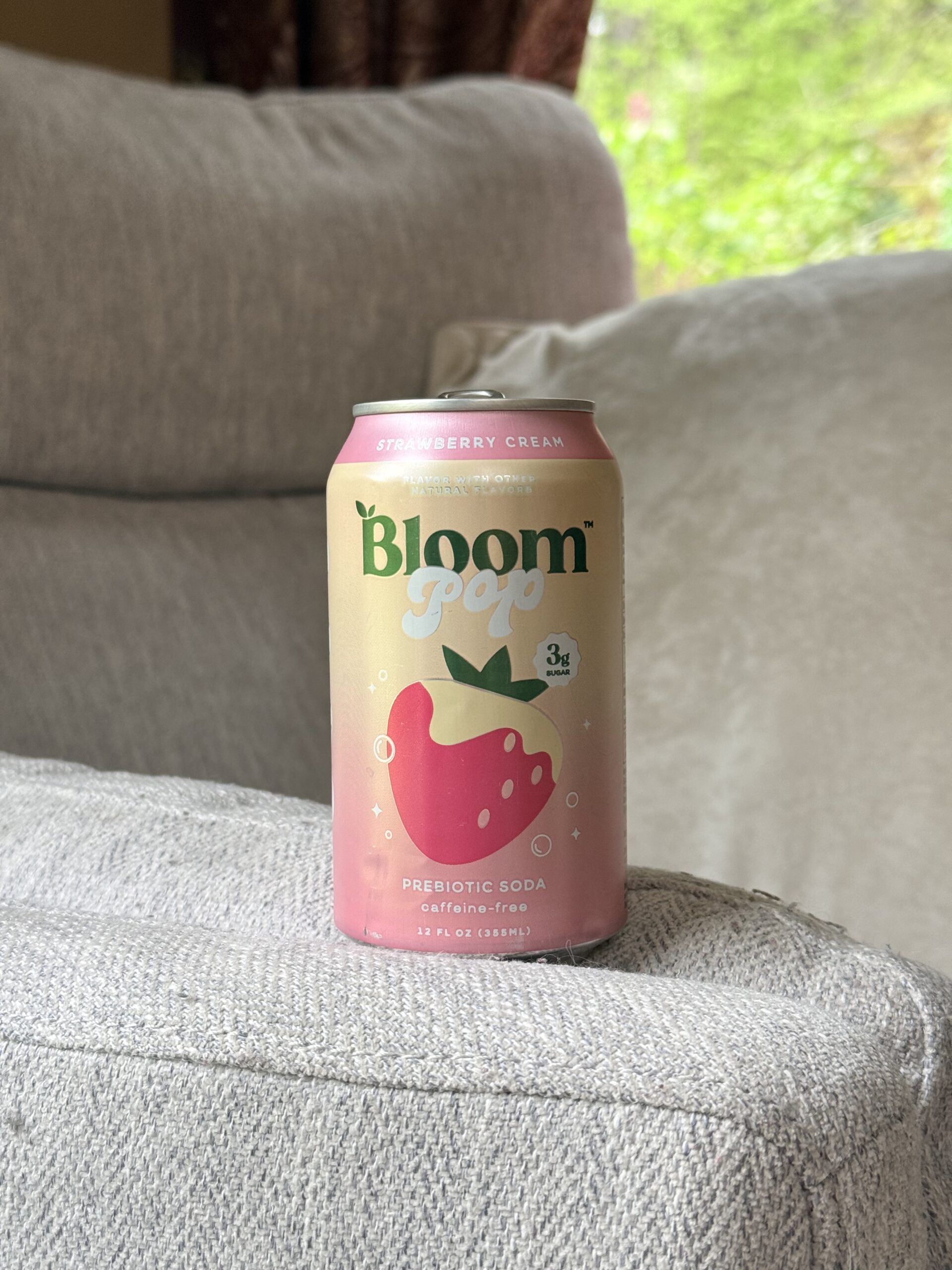 A 12 fl. oz. can of Bloom Pop Prebiotic Soda in the flavor Strawberry Cream.